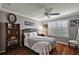 Comfortable bedroom features a ceiling fan, plantation shutters, and stylish decor on hardwood floors at 1053 Alcove Loop, The Villages, FL 32162