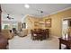 An inviting dining area featuring a wooden table, chandelier, and an open view into the living room at 1053 Alcove Loop, The Villages, FL 32162
