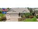 Charming single-story home with manicured lawn, lush landscaping, and three-car garage at 1053 Alcove Loop, The Villages, FL 32162