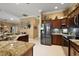 Spacious kitchen featuring stainless steel appliances, granite countertops, and dark wood cabinetry at 1053 Alcove Loop, The Villages, FL 32162