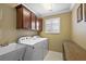 Functional laundry room with cabinets, sink, and washer/dryer hookups at 1053 Alcove Loop, The Villages, FL 32162