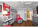 Comfortable living room with hardwood floors featuring red recliners and college sports decor, very cozy at 1053 Alcove Loop, The Villages, FL 32162
