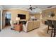 Relaxing living room showcasing tile floors, a large TV, and a view of the dining area and lanai at 1053 Alcove Loop, The Villages, FL 32162