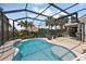 Beautiful screened-in pool area with mature landscaping and covered outdoor seating at 1053 Alcove Loop, The Villages, FL 32162