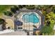 Overhead view of a private screened-in pool featuring a kidney shape, clear water, and umbrella-shaded furniture at 1053 Alcove Loop, The Villages, FL 32162