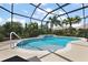 Beautiful pool area with clear blue water, lush landscaping, and a peaceful waterfall feature at 1053 Alcove Loop, The Villages, FL 32162