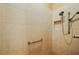Shower showcasing a tile surround, a handrail, and an adjustable shower head at 1053 Alcove Loop, The Villages, FL 32162