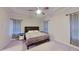 A serene main bedroom features soft lighting, plush carpet, neutral tones and ample space for relaxation at 108 Whispering Pines Way, Davenport, FL 33837
