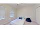 A cozy bedroom with two sunny windows and plush carpet features a comfortable beanbag at 108 Whispering Pines Way, Davenport, FL 33837