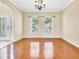 Bright dining room featuring wood floors, large windows, and an elegant chandelier at 108 Whispering Pines Way, Davenport, FL 33837