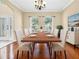 Dining room with wood floors, bright windows, and white dining chairs at 108 Whispering Pines Way, Davenport, FL 33837