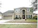 Charming two-story home with a manicured lawn and a two-car garage at 108 Whispering Pines Way, Davenport, FL 33837