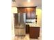 The stainless steel refrigerator complements the kitchen's design, featuring upper cabinets and granite countertop at 108 Whispering Pines Way, Davenport, FL 33837