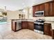 Updated kitchen with granite countertops, stainless steel appliances, and dark wood cabinets at 108 Whispering Pines Way, Davenport, FL 33837