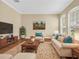 Living room with neutral furniture, hardwood floors, and bright windows at 108 Whispering Pines Way, Davenport, FL 33837