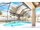 Inviting screened-in pool area featuring a sparkling pool with a tranquil waterfall and lush landscaping at 108 Whispering Pines Way, Davenport, FL 33837