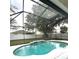 Relaxing enclosed pool area complete with a waterfall feature, offering privacy and a tranquil ambiance at 108 Whispering Pines Way, Davenport, FL 33837