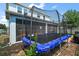 View of backyard with screened in lanai and in-ground trampoline, all within a fenced yard at 1155 Dora Parc Ln, Mount Dora, FL 32757