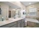 Bathroom boasts double sinks, soaking tub, tiled walls, and a separate glass shower at 1155 Dora Parc Ln, Mount Dora, FL 32757