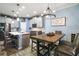 Dining room and kitchen area featuring a central island with seating, modern light fixtures, and stainless appliances at 1155 Dora Parc Ln, Mount Dora, FL 32757