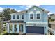 Charming two-story home with a covered porch, a two-car garage, and beautiful blue stucco at 1155 Dora Parc Ln, Mount Dora, FL 32757