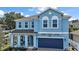 Charming two-story home with a covered front porch and a brick paver driveway leading to the garage at 1155 Dora Parc Ln, Mount Dora, FL 32757