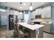 Well-lit kitchen featuring a center island with seating, stainless steel appliances, and modern fixtures at 1155 Dora Parc Ln, Mount Dora, FL 32757
