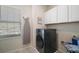 Laundry room features a modern washer, white cabinets, and an ironing board at 1155 Dora Parc Ln, Mount Dora, FL 32757