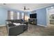 Comfortable living room featuring a leather sectional, ceiling fan and decorative curtains at 1155 Dora Parc Ln, Mount Dora, FL 32757