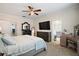 Bright main bedroom featuring a plush bed, dark wood dresser, vanity, and a flat screen television at 1155 Dora Parc Ln, Mount Dora, FL 32757