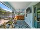 Enclosed patio featuring a wooden bar, ceiling fan, seating, and large windows at 1155 Dora Parc Ln, Mount Dora, FL 32757