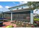 View of screened in lanai with furniture and plants, paver patio and walkway on manicured lawn at 1155 Dora Parc Ln, Mount Dora, FL 32757