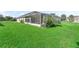 Expansive backyard features a lush lawn, mature landscaping, and a screened patio at 12118 Se 175Th Loop, Summerfield, FL 34491