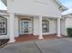 Covered porch featuring classic white columns and a glass front door at 12118 Se 175Th Loop, Summerfield, FL 34491