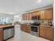 Kitchen with stainless steel appliances and wooden cabinets, open to the cozy living room at 12118 Se 175Th Loop, Summerfield, FL 34491