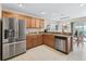 Well-equipped kitchen with stainless steel refrigerator, sink, dishwasher and wooden cabinets at 12118 Se 175Th Loop, Summerfield, FL 34491
