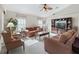 Cozy living room with comfortable seating, a ceiling fan and natural light at 12118 Se 175Th Loop, Summerfield, FL 34491