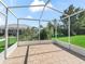 Screened patio features a neutral tile floor and views of a manicured lawn and landscaping at 12118 Se 175Th Loop, Summerfield, FL 34491