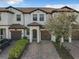 Charming townhome with well-maintained landscaping, a brick driveway and a two car garage at 1342 Royal Saint George Blvd, Davenport, FL 33896