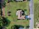Aerial view of property with indicated lot lines featuring a large lawn, a screened in lanai, and mature trees at 13875 Se 97Th Ave, Summerfield, FL 34491
