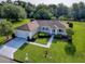 Aerial view of a single-story home with manicured lawn and lush landscaping, showcasing its prime location at 13875 Se 97Th Ave, Summerfield, FL 34491