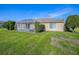 Manicured backyard featuring a covered patio and lush lawn, perfect for enjoying the outdoors at 13875 Se 97Th Ave, Summerfield, FL 34491