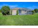 A well-maintained backyard with lush green grass and a screened-in patio that extends the living space outdoors at 13875 Se 97Th Ave, Summerfield, FL 34491