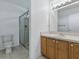 Well-lit bathroom featuring tiled floors, toilet, shower, and sink with vanity at 13875 Se 97Th Ave, Summerfield, FL 34491