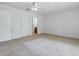 Spacious bedroom with neutral carpet, ceiling fan, and easy access to the bathroom at 13875 Se 97Th Ave, Summerfield, FL 34491