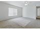 Bright bedroom featuring a large window, neutral carpet, and a ceiling fan at 13875 Se 97Th Ave, Summerfield, FL 34491