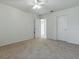 Bright bedroom features neutral carpet, ceiling fan, and convenient closet and bathroom access at 13875 Se 97Th Ave, Summerfield, FL 34491