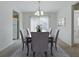 Elegant dining area with modern chandelier, table setting, and view of the outside through sliding doors at 13875 Se 97Th Ave, Summerfield, FL 34491