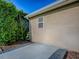 Side yard exterior with concrete slab, bush, and stucco wall at 13875 Se 97Th Ave, Summerfield, FL 34491