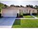 Charming single-story home featuring a well-manicured lawn, two car garage, and inviting landscaping at 13875 Se 97Th Ave, Summerfield, FL 34491